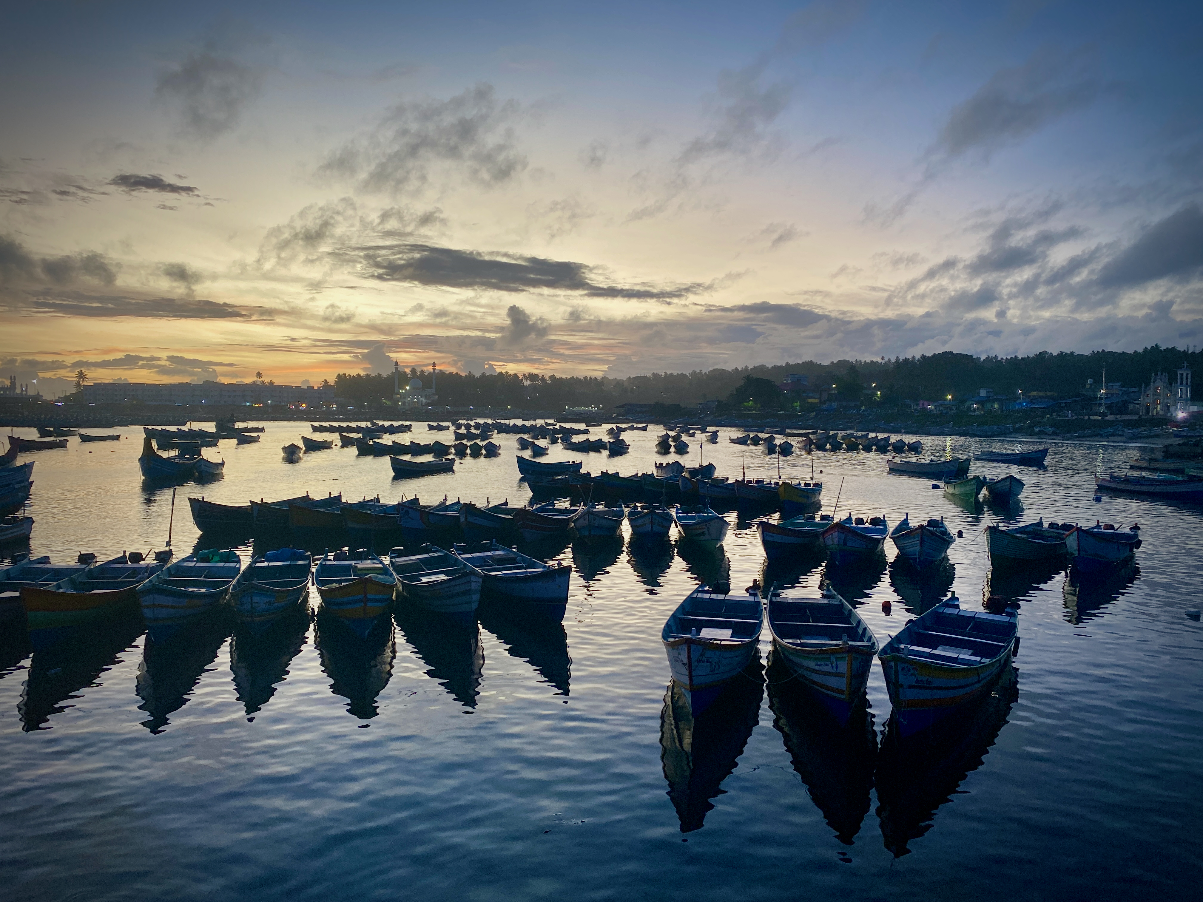 Boats drift in the ballet of twilight's embrace.